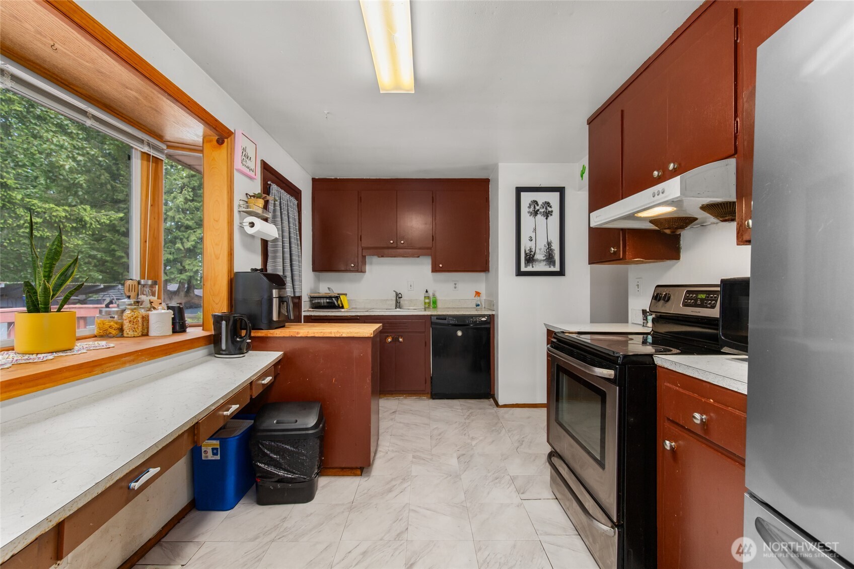 17543 7th Avenue Northeast Shoreline, WA 98155 - Photo 12 of 37 a kitchen with wooden cabinets a sink dishwasher and a stove top oven with wooden floor