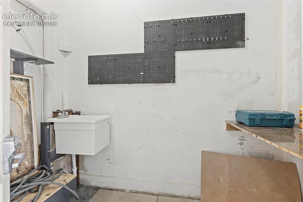 1563 Monterey Road, Unit D Colorado Springs, CO 80910 - Photo 19 of 22 a bathroom with a sink a mirror and a lamp