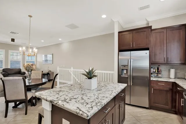 a kitchen with stainless steel appliances granite countertop a kitchen island a table and chairs