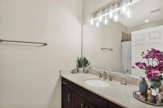 a bathroom with a granite countertop sink a large mirror and vanity