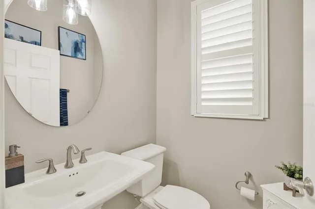 a bathroom with a sink mirror and toilet