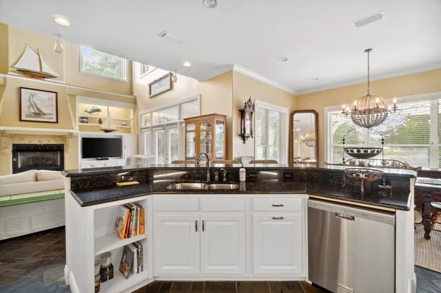 a kitchen with stainless steel appliances granite countertop a stove a sink and a granite counter tops with white cabinets