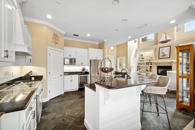 a kitchen with stainless steel appliances a stove a sink and white cabinets