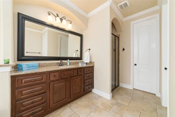 a bathroom with a granite countertop double vanity sink and a mirror
