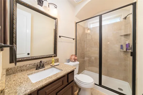 a bathroom with a granite countertop sink toilet and shower