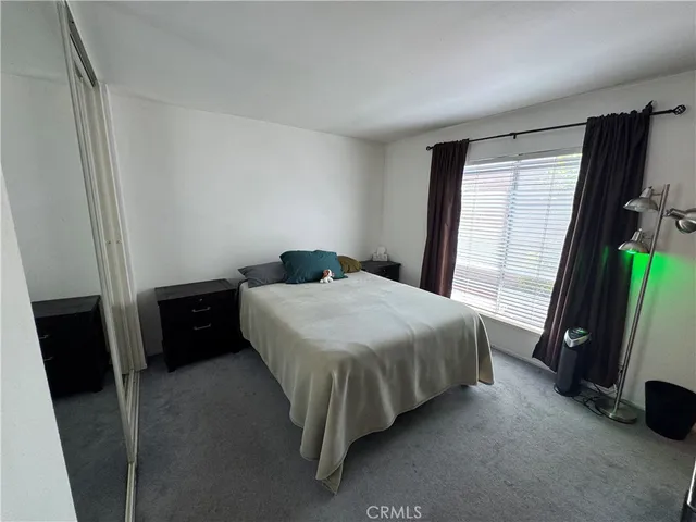 a bedroom with a bed and a flat tv screen on a dresser