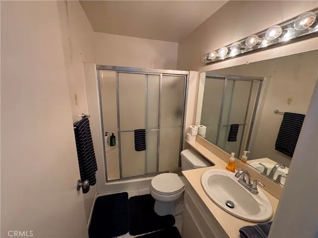 a bathroom with a sink a toilet and shower a mirror