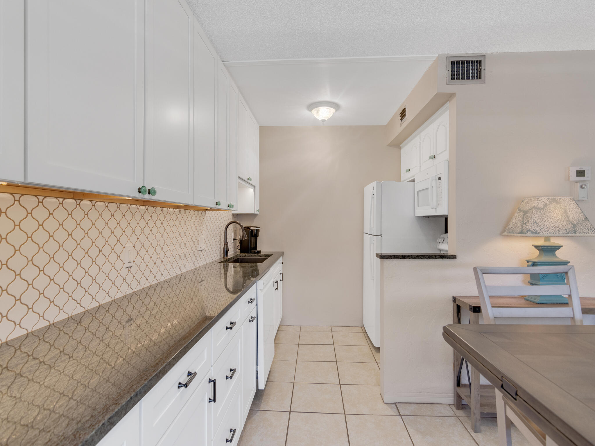 Undisclosed Address Vero Beach, FL 32960 - Photo 12 of 29 a kitchen with white cabinets a sink and dishwasher