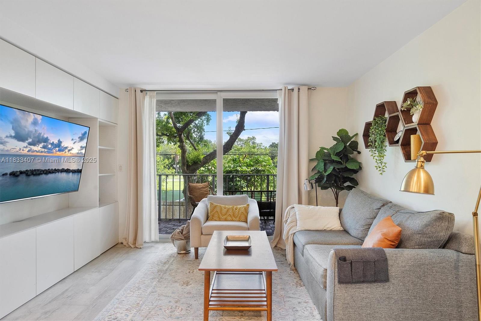 650 Northeast 64th Street, Unit G210 Miami, FL 33138 - Photo 11 of 25 a living room with furniture and a large window