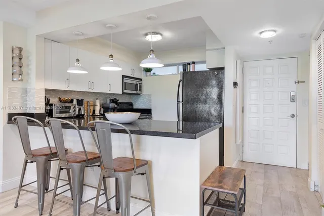a kitchen with stainless steel appliances kitchen island granite countertop a table and chairs in it