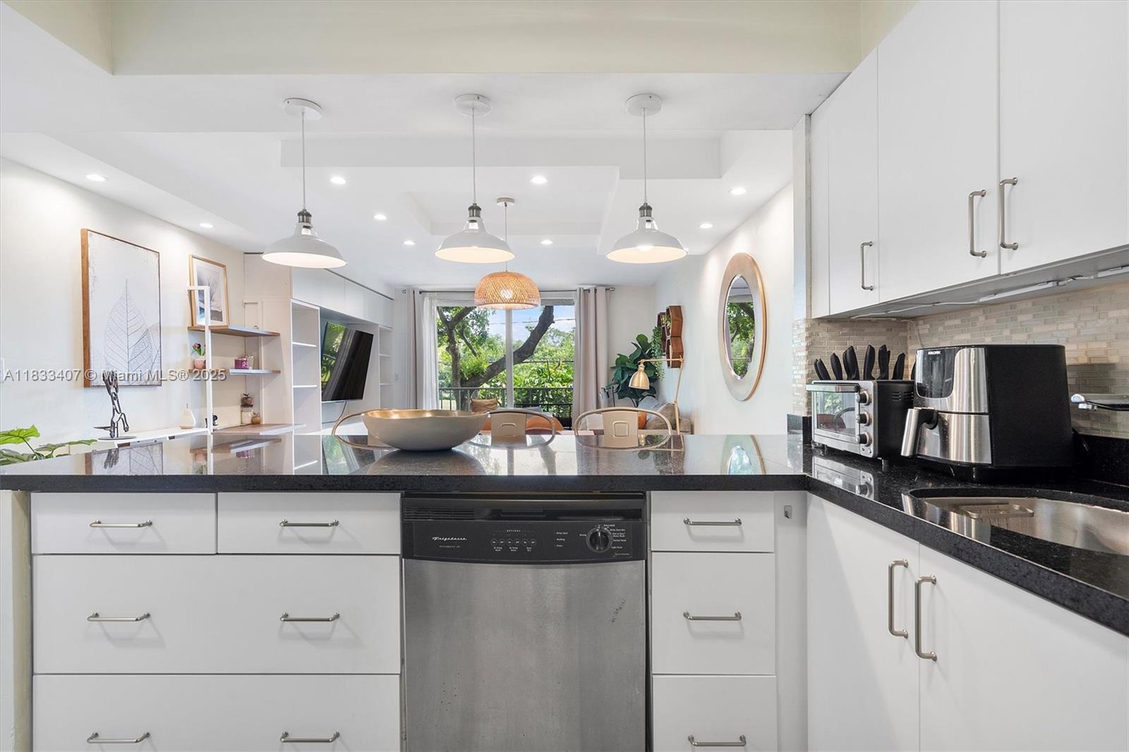 650 Northeast 64th Street, Unit G210 Miami, FL 33138 - Photo 16 of 25 a kitchen with granite countertop a sink and cabinets