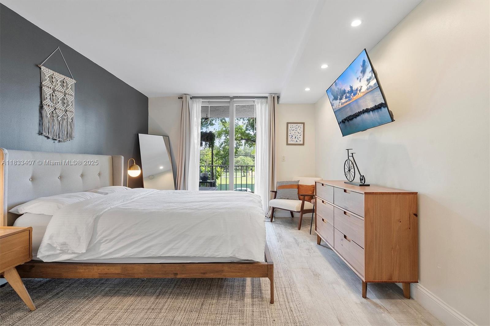 650 Northeast 64th Street, Unit G210 Miami, FL 33138 - Photo 17 of 25 a bedroom with a bed and wooden floor