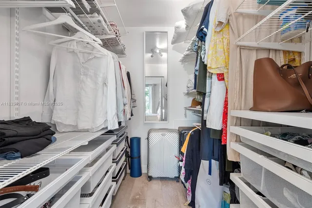 a view of walk in closet with clothes and shoes
