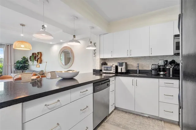a kitchen with granite countertop white cabinets and white appliances