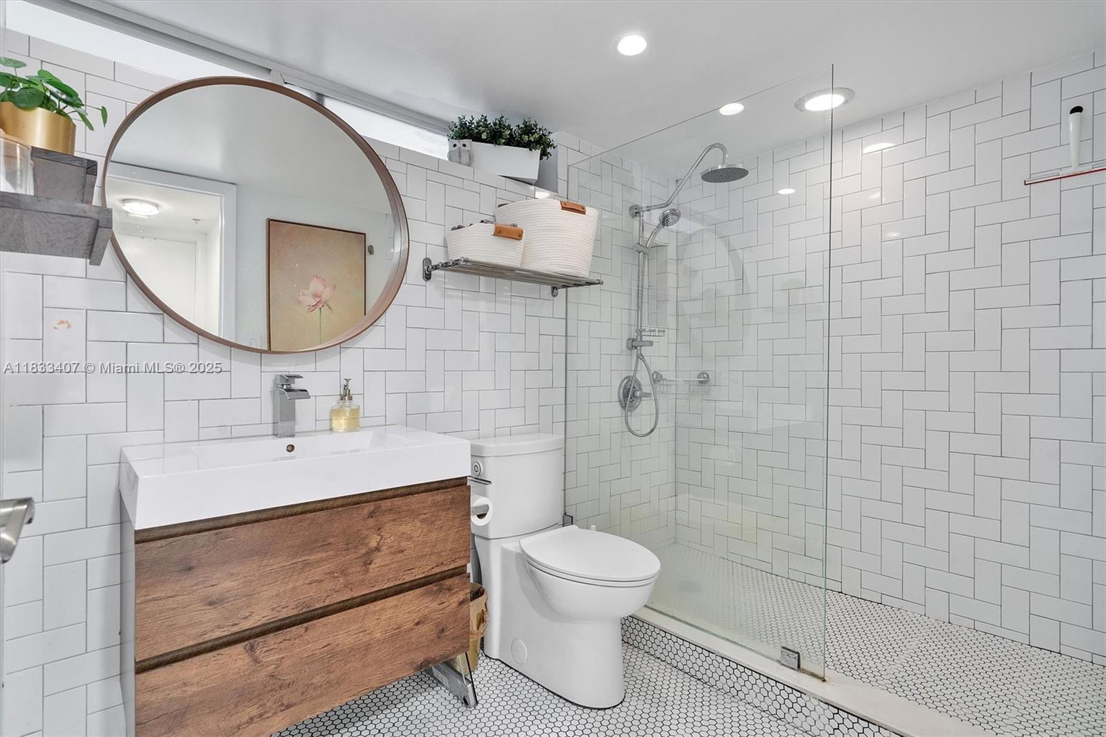 650 Northeast 64th Street, Unit G210 Miami, FL 33138 - Photo 7 of 25 a bathroom with a sink a toilet and a mirror