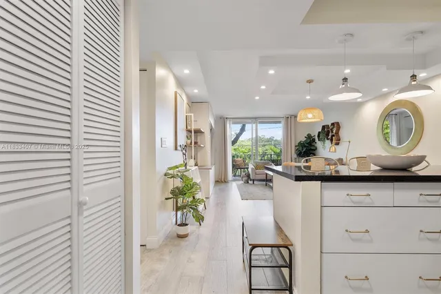 a kitchen with white cabinets and chandelier