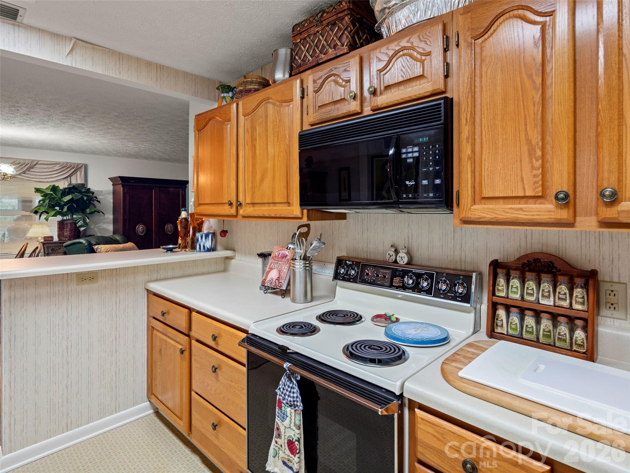 812 Crab Creek Road Hendersonville, NC 28739 - Photo 14 of 33 a kitchen with stainless steel appliances a stove a microwave a sink and cabinets