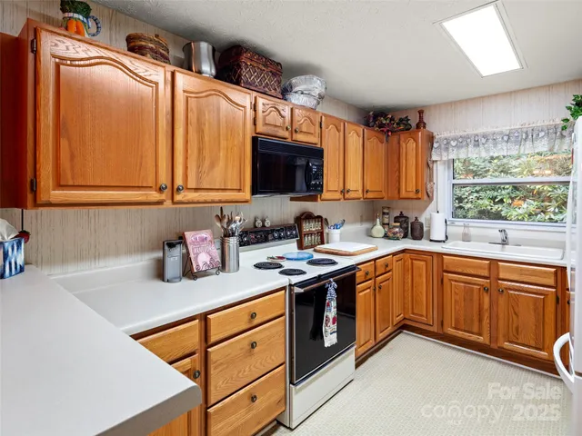 a kitchen with stainless steel appliances a stove a microwave a sink and cabinets