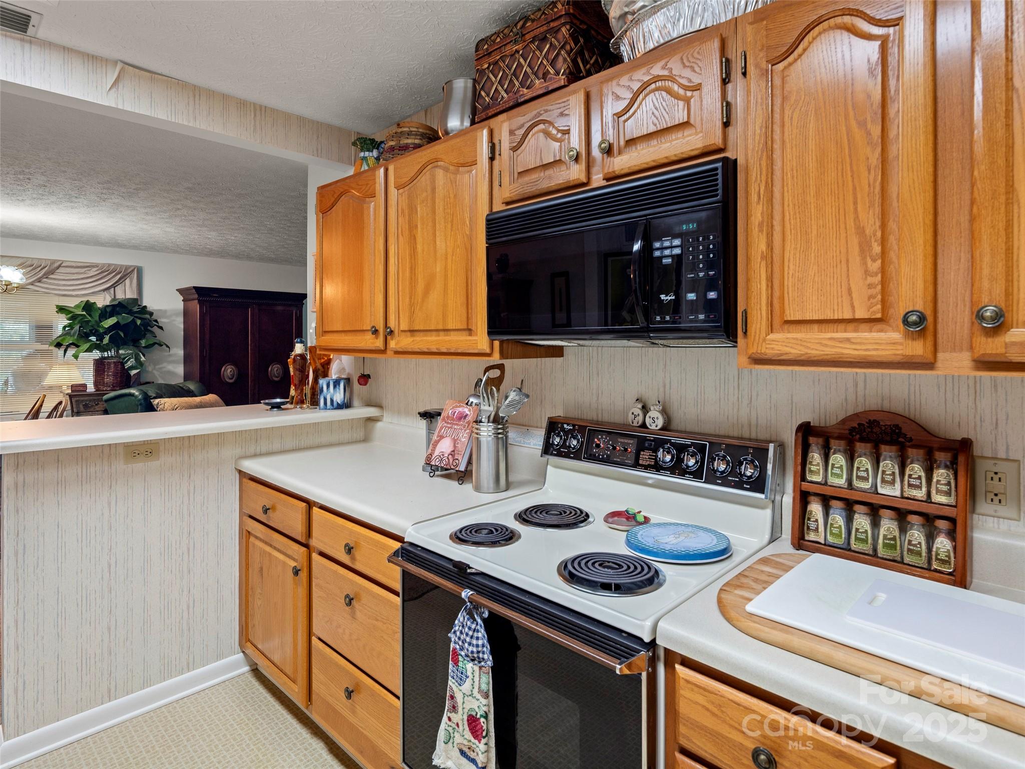 812 Crab Creek Road Hendersonville, NC 28739 - Photo 15 of 34 a kitchen with stainless steel appliances a stove a microwave a sink and cabinets