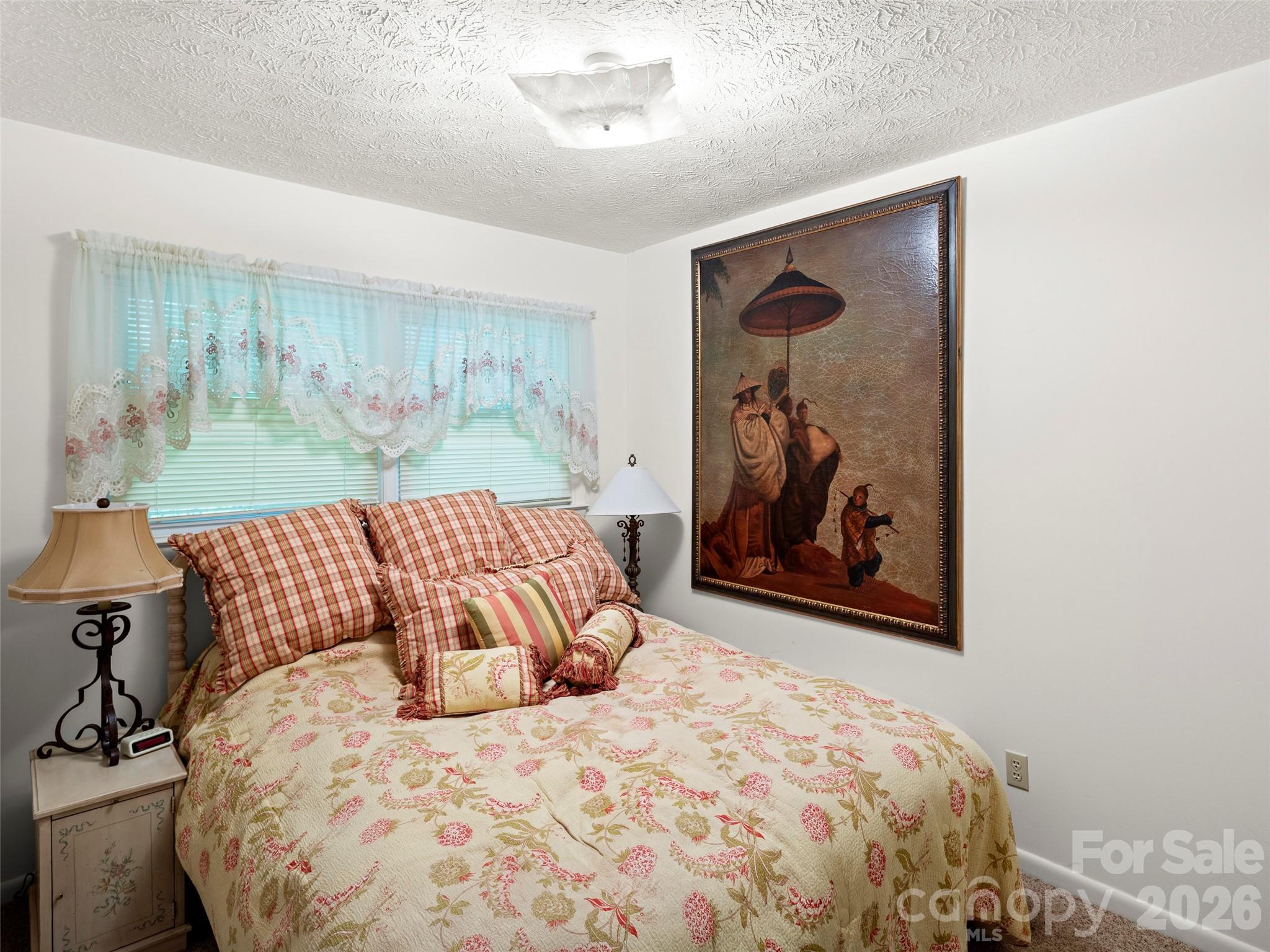 812 Crab Creek Road Hendersonville, NC 28739 - Photo 16 of 33 a bedroom with a large bed and a painting on the wall