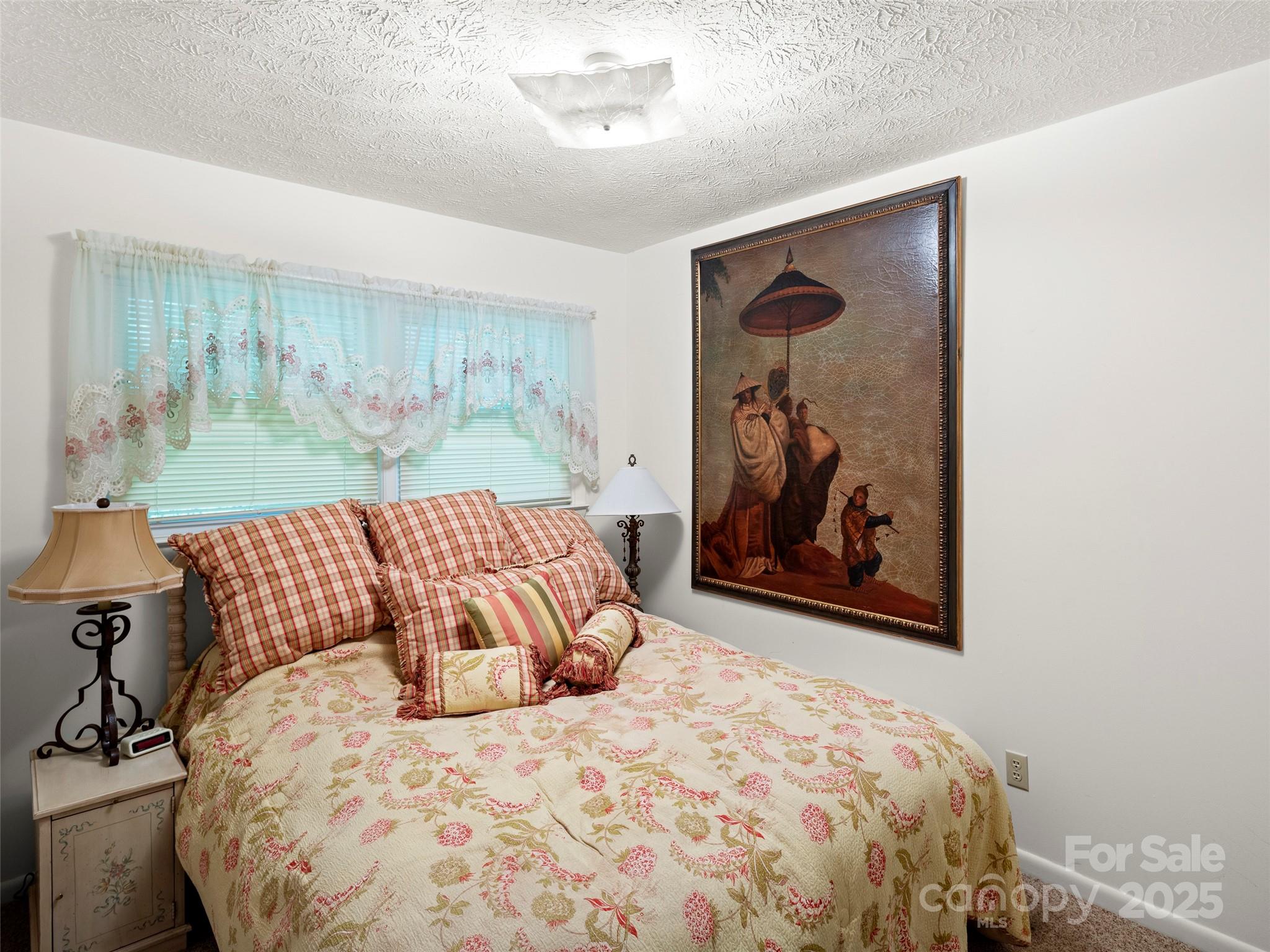 812 Crab Creek Road Hendersonville, NC 28739 - Photo 17 of 34 a bedroom with a large bed and a painting on the wall