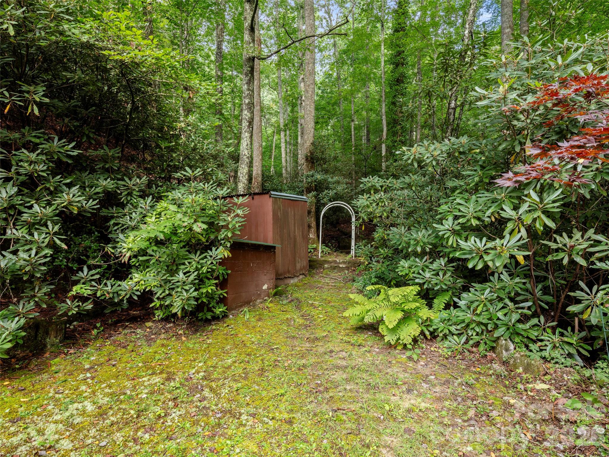 812 Crab Creek Road Hendersonville, NC 28739 - Photo 23 of 33 a backyard of a house with lots of green space and garden