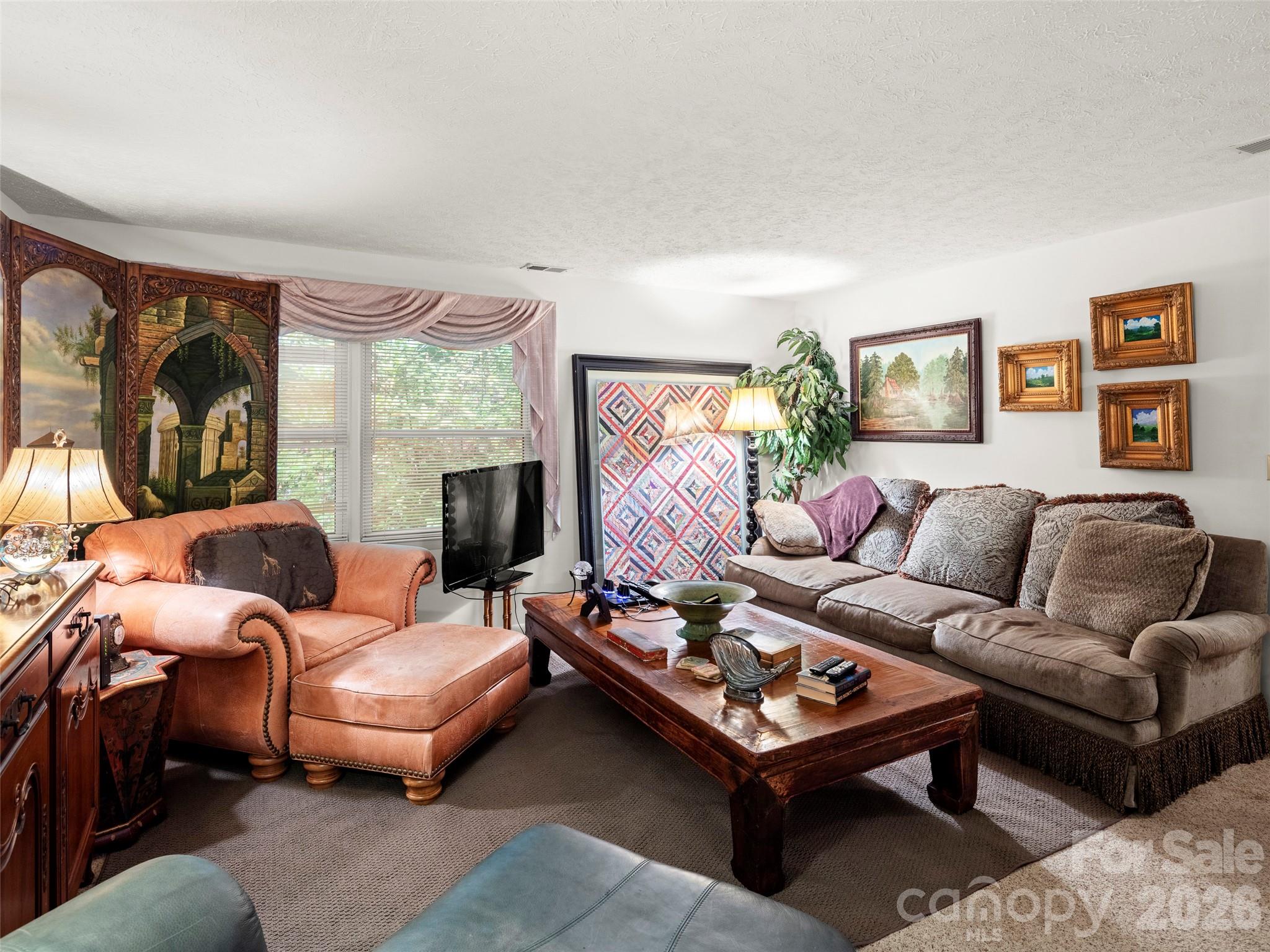 812 Crab Creek Road Hendersonville, NC 28739 - Photo 8 of 33 a living room with furniture and a floor to ceiling window