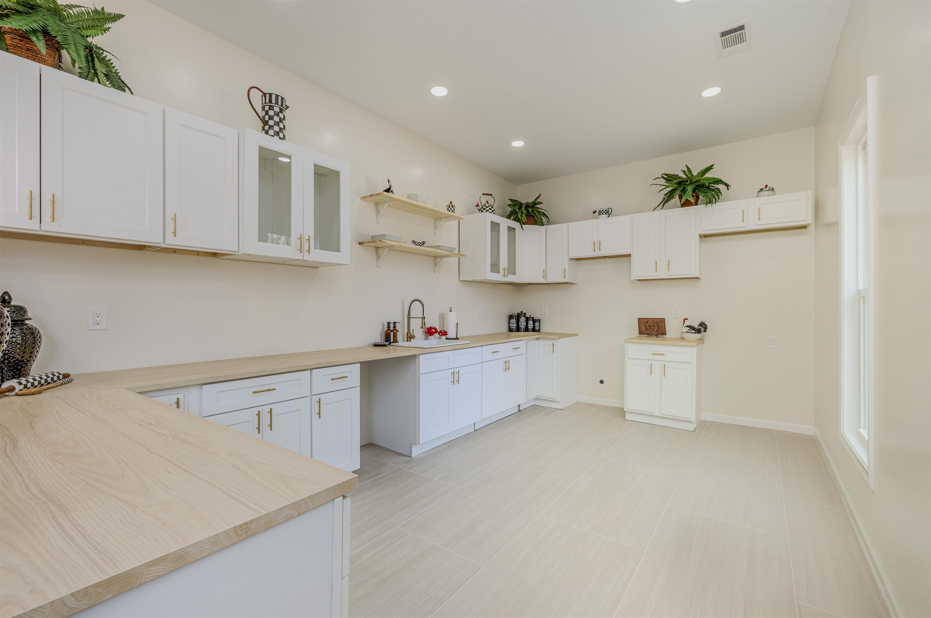 1069 Shaw Place Memphis, TN 38126 - Photo 9 of 23 Kitchen with a sink, glass insert cabinets, light countertops, visible vents, and recessed lighting