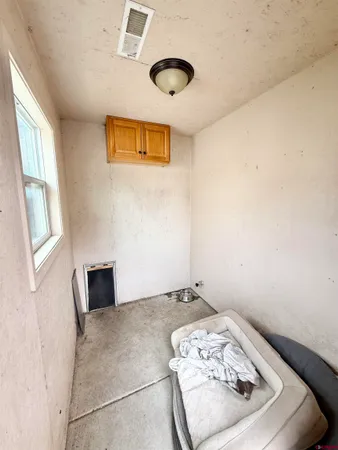 a bedroom with a bed chandelier and a window