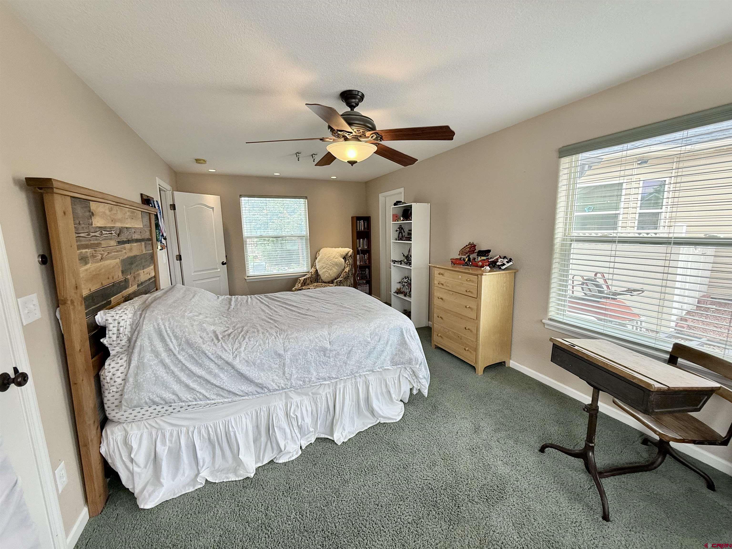 2941 Lost Creek Road North Montrose, CO 81401 - Photo 24 of 45 a bedroom with a bed and a chandelier