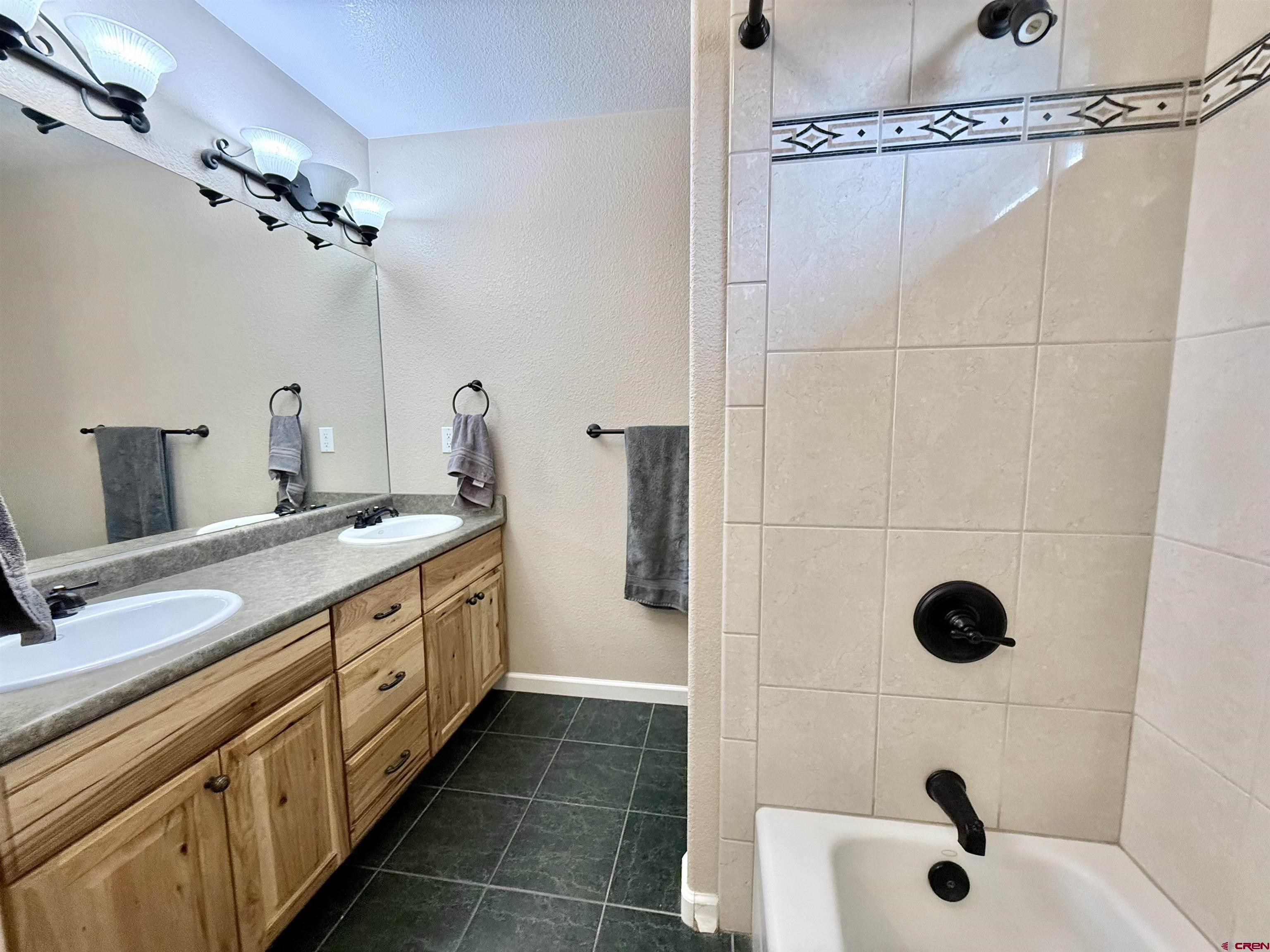 2941 Lost Creek Road North Montrose, CO 81401 - Photo 30 of 45 a bathroom with a double vanity sink a toilet and shower