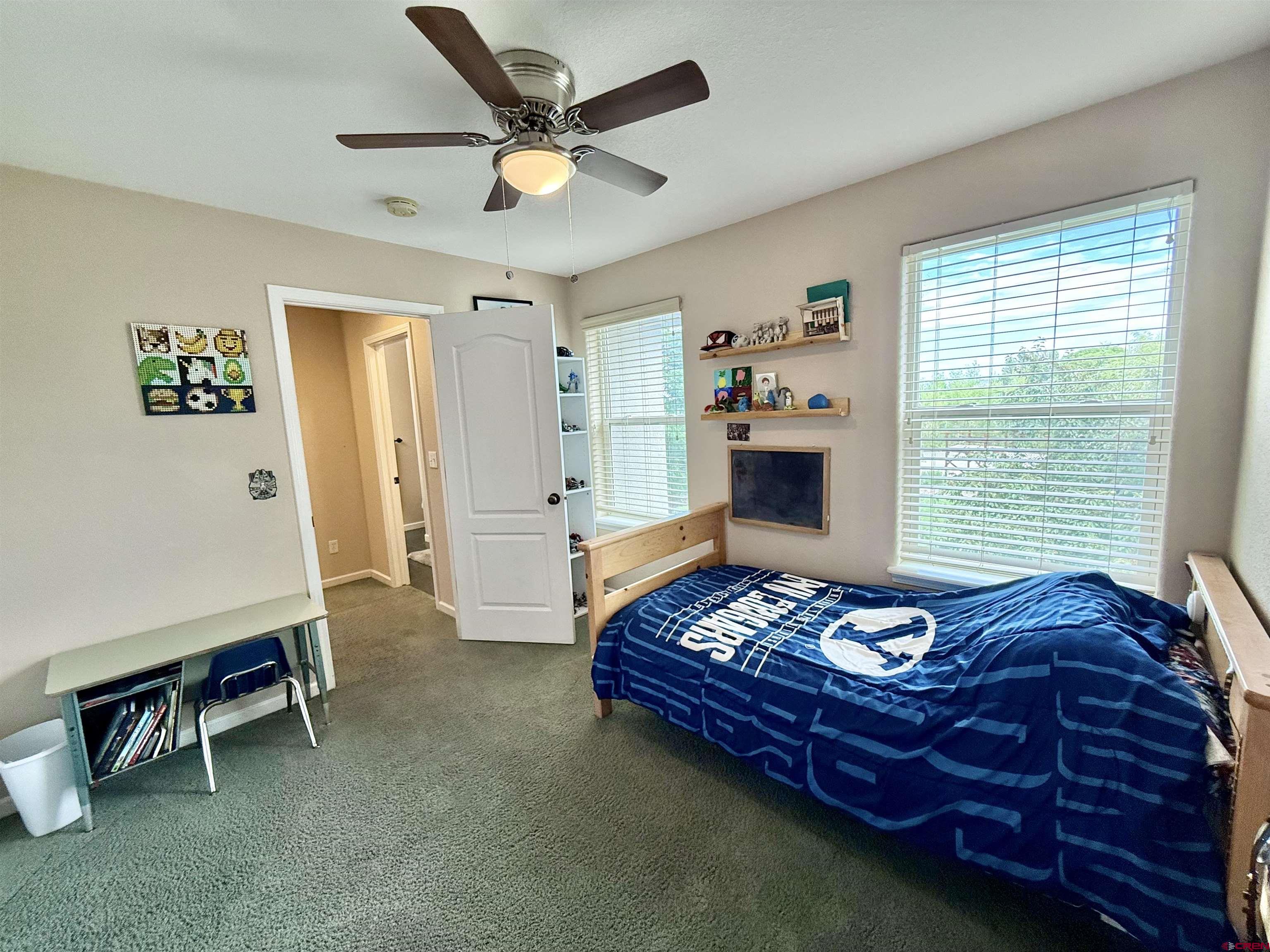 2941 Lost Creek Road North Montrose, CO 81401 - Photo 36 of 45 a bedroom with a bed and a chandelier