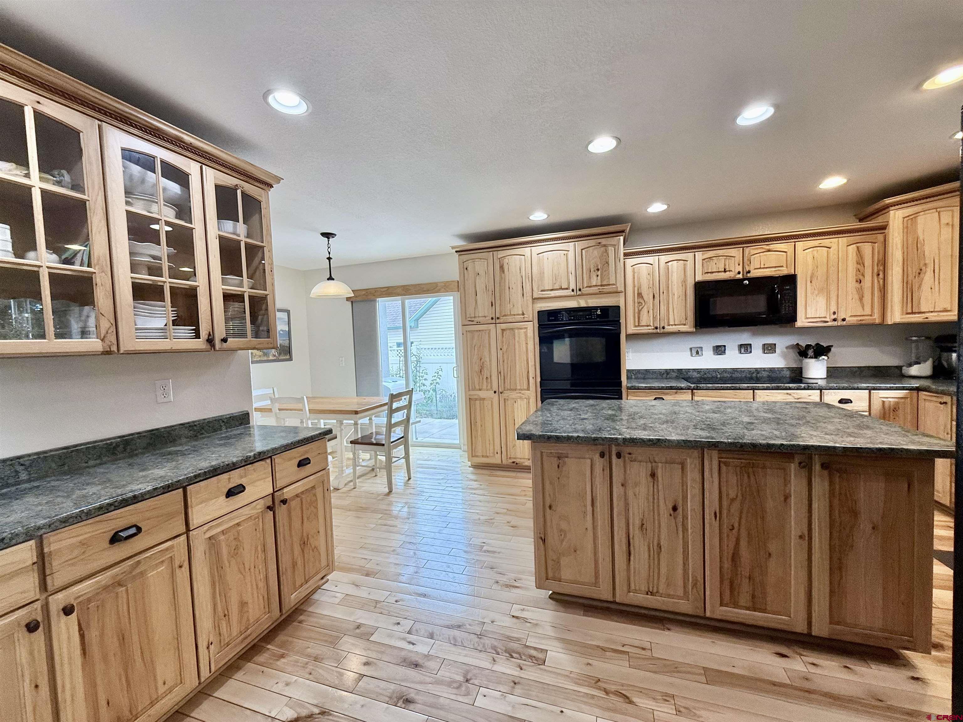 2941 Lost Creek Road North Montrose, CO 81401 - Photo 4 of 45 a kitchen with stainless steel appliances granite countertop a stove top oven a sink dishwasher and a microwave oven with large wooden cabinets