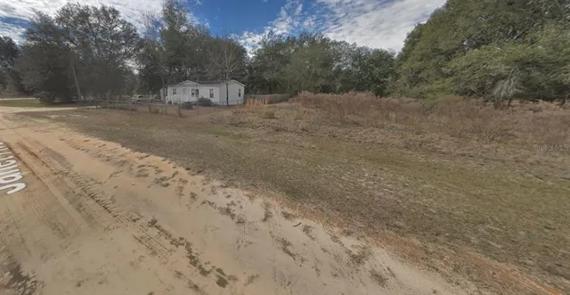 a view of a field with trees in the background