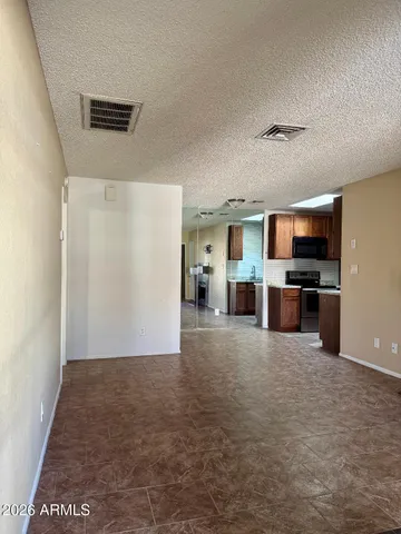 a view of kitchen with stainless steel appliances kitchen island granite countertop a refrigerator and a stove top oven