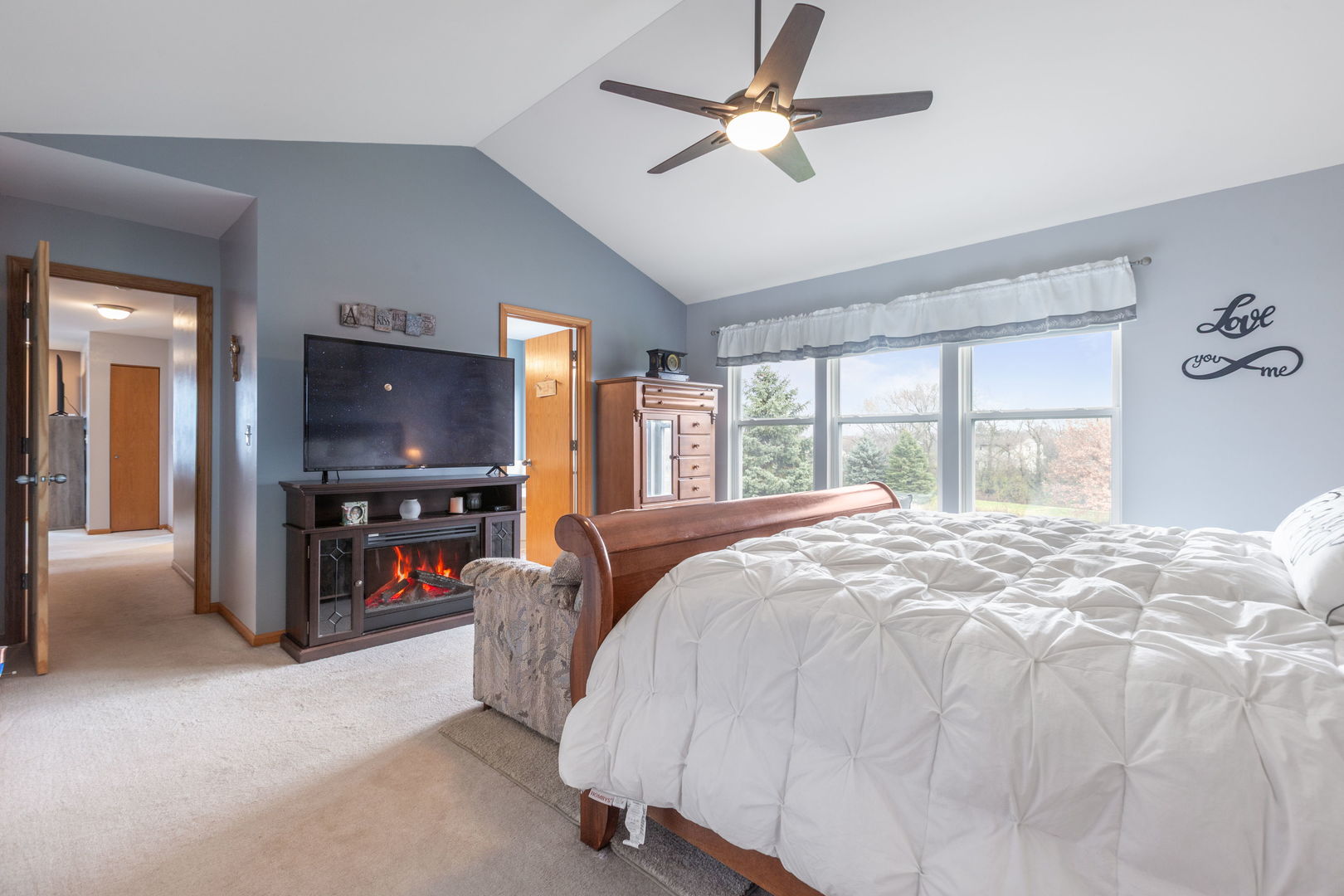 105 Inverness Court Round Lake, IL 60073 - Photo 17 of 31 a spacious bedroom with a large bed and a chandelier