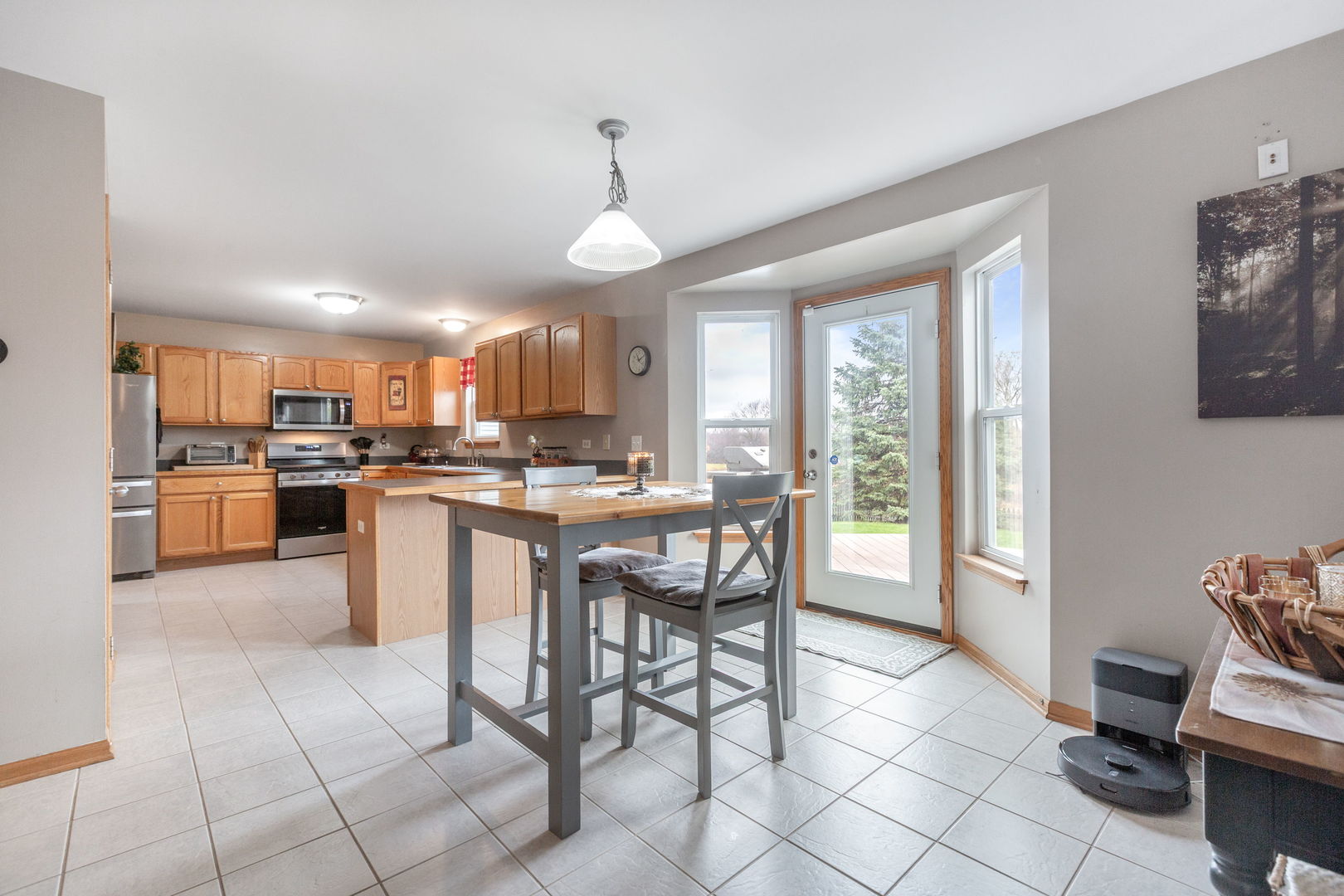 105 Inverness Court Round Lake, IL 60073 - Photo 9 of 31 a kitchen with stainless steel appliances granite countertop a stove top oven a sink a dining table and chairs