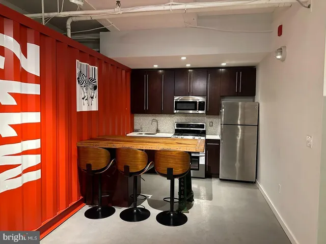 a kitchen with refrigerator and chairs