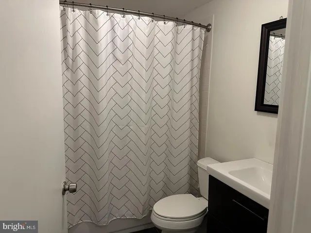a white toilet sitting next to a shower curtain
