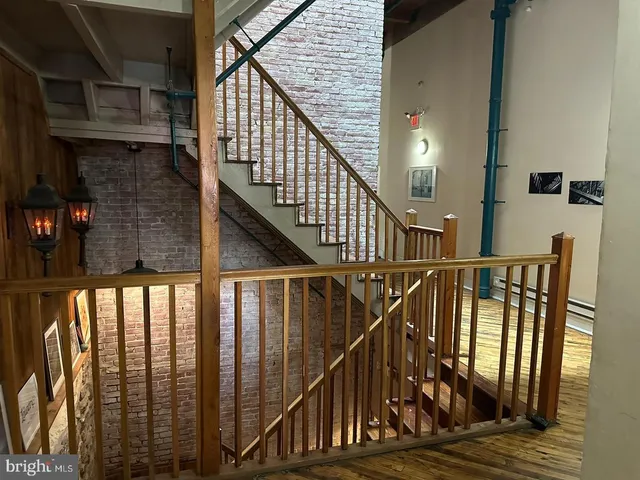 a view of staircase with railing and white walls