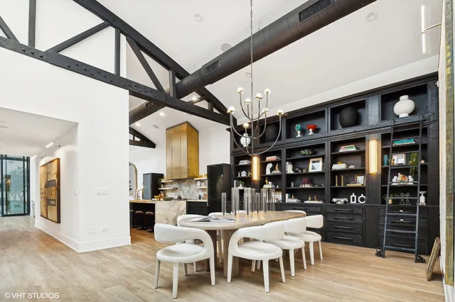 a dining room with stainless steel appliances kitchen island granite countertop a table chairs and a view of living room