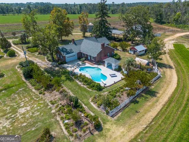 an aerial view of a house with a garden and lake view