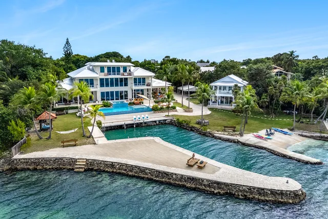 an aerial view of a house with swimming pool garden and lake view