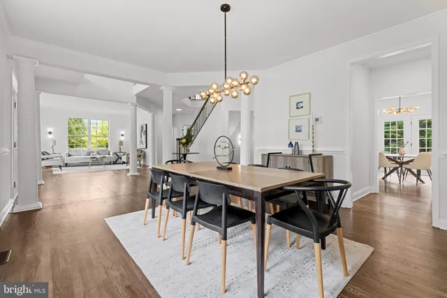 a view of a dining room with furniture a chandelier and wooden floor