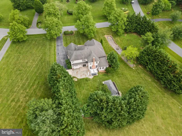 a front view of a house with a yard and trees