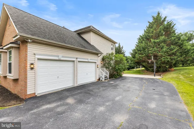 a dining room with wooden floor a chandelier a wooden table and chairs