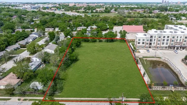 an aerial view of residential houses with outdoor space and trees
