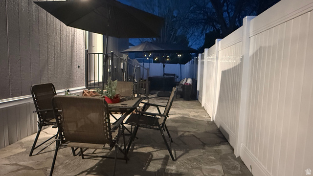 502 West 725 North Logan, UT 84321 - Photo 24 of 25 Patio at night with outdoor dining space, a fenced backyard, a patio, and a gazebo