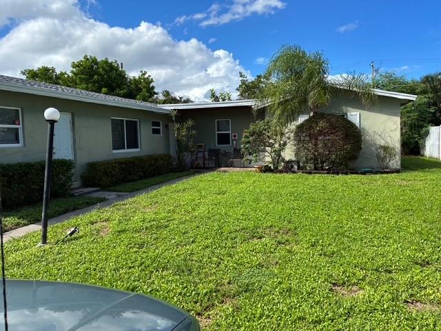 1911 Northeast 28th Street, Unit 1 Pompano Beach, FL 33064 - Photo 1 of 7 a front view of a house with garden