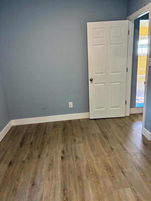 1911 Northeast 28th Street, Unit 1 Pompano Beach, FL 33064 - Photo 4 of 7 a view of an empty room with wooden floor and closet
